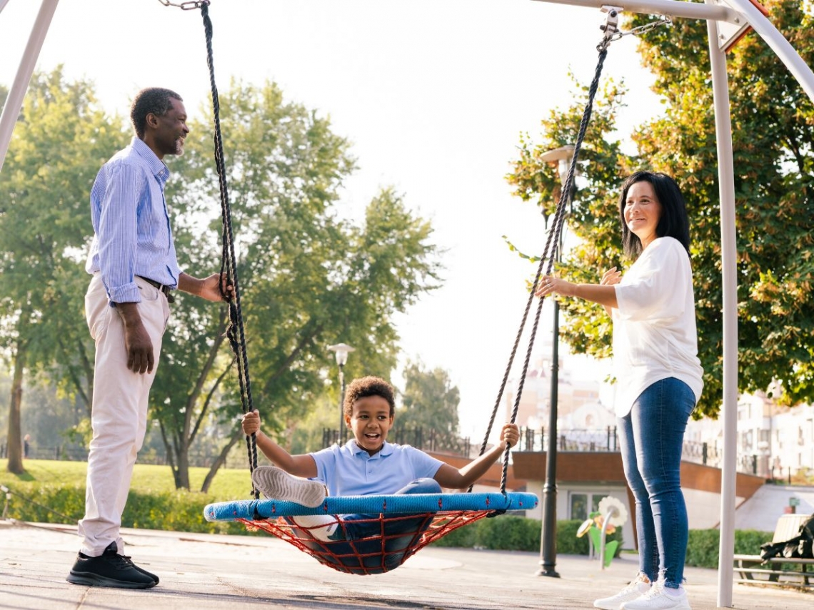 a family playing on a small swing set.jpg