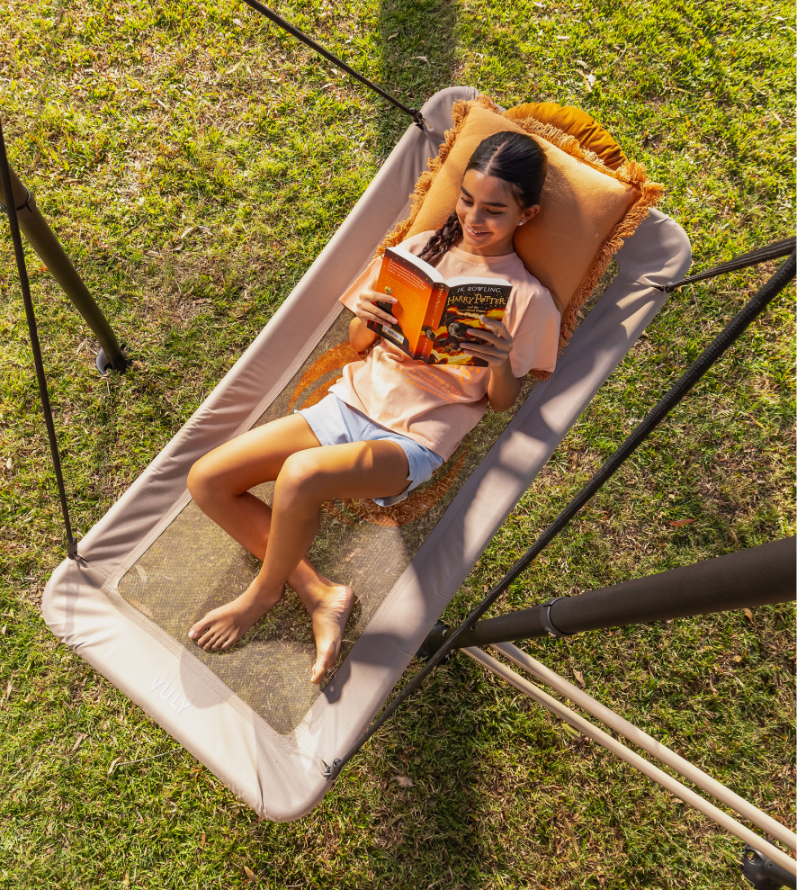 Child reading book on swing