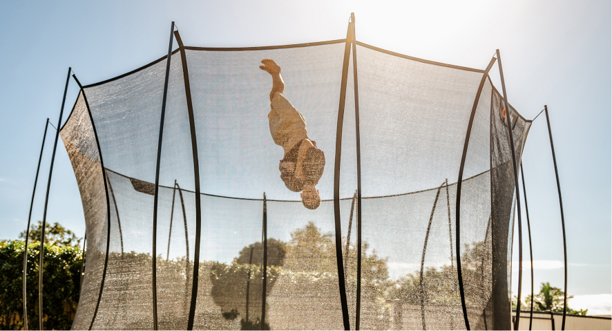 Child performing a somersault on a trampoline