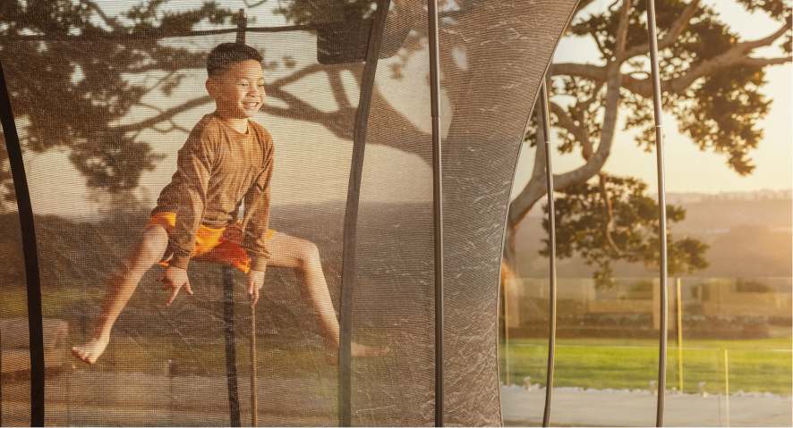 Kid performing a trick on a trampoline