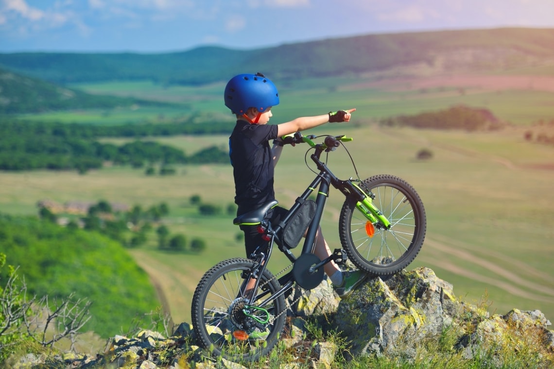Child on his mountain bike on top of a rock hillside
