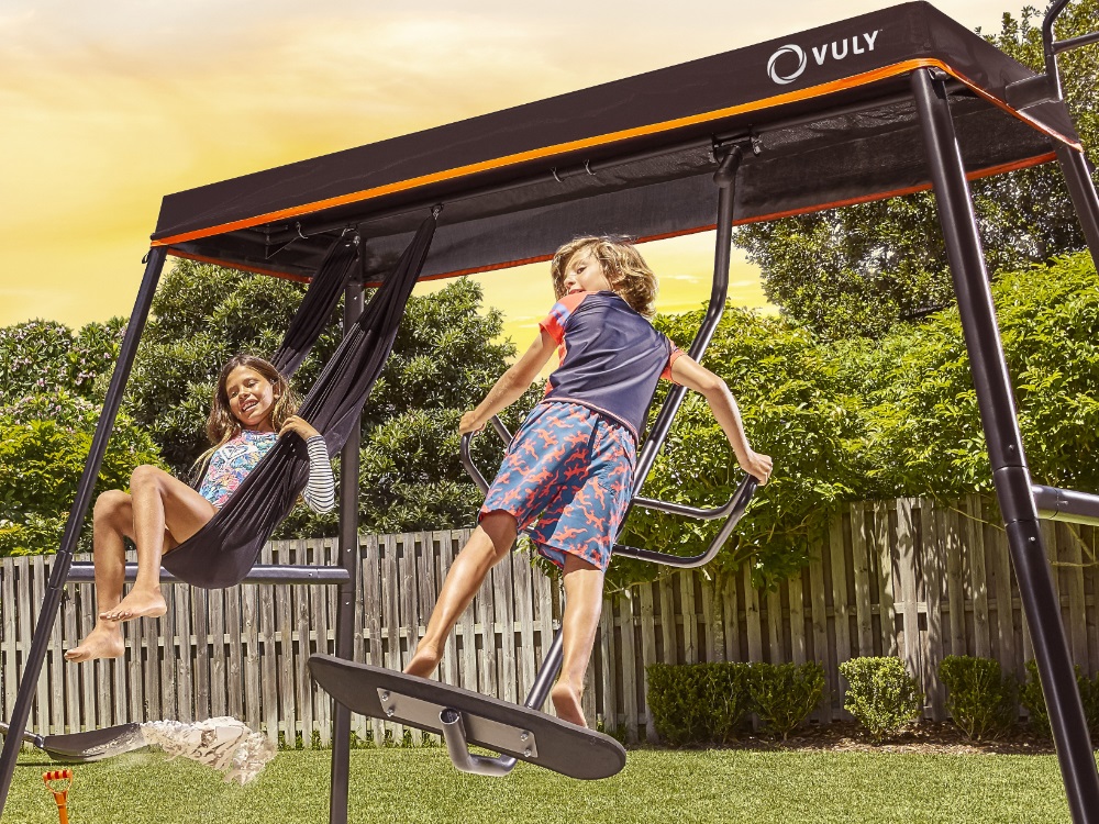 Boy and girl playing on Max Spin and Yoga Swings