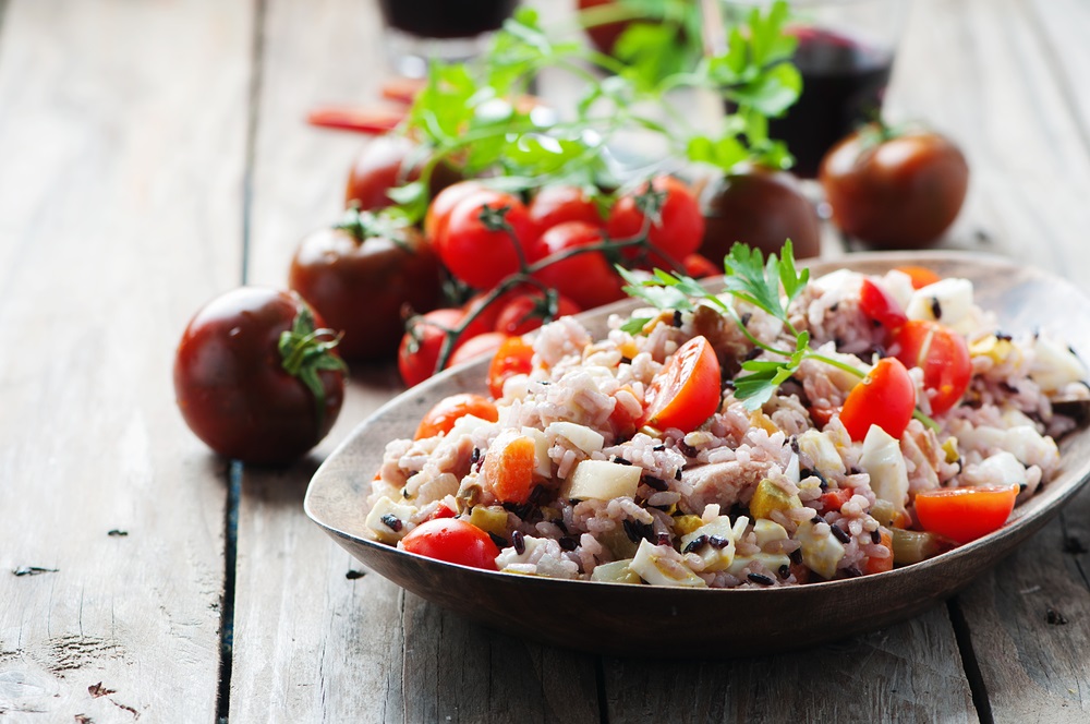 Brown rice and tomato in a bowl placed on a table