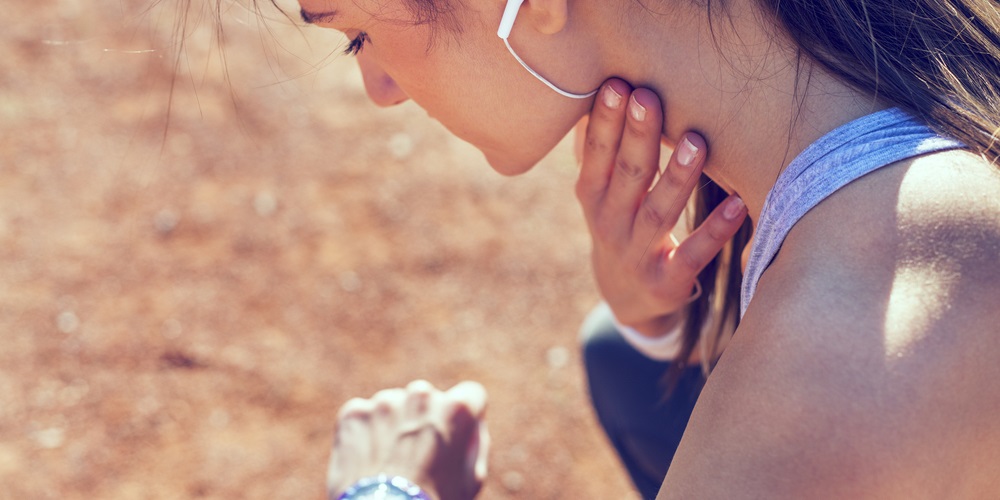 Woman checking her pulse on her neck