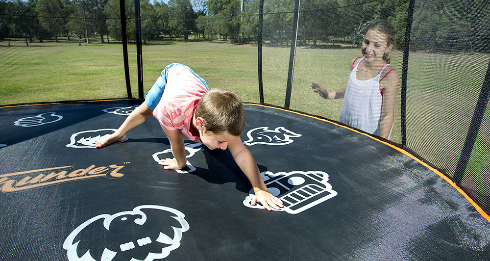 Boy playing twister on his Vuly trampoline