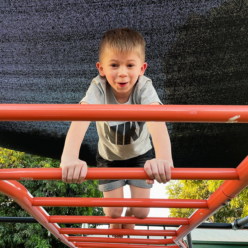 kid playing on monkey bars 