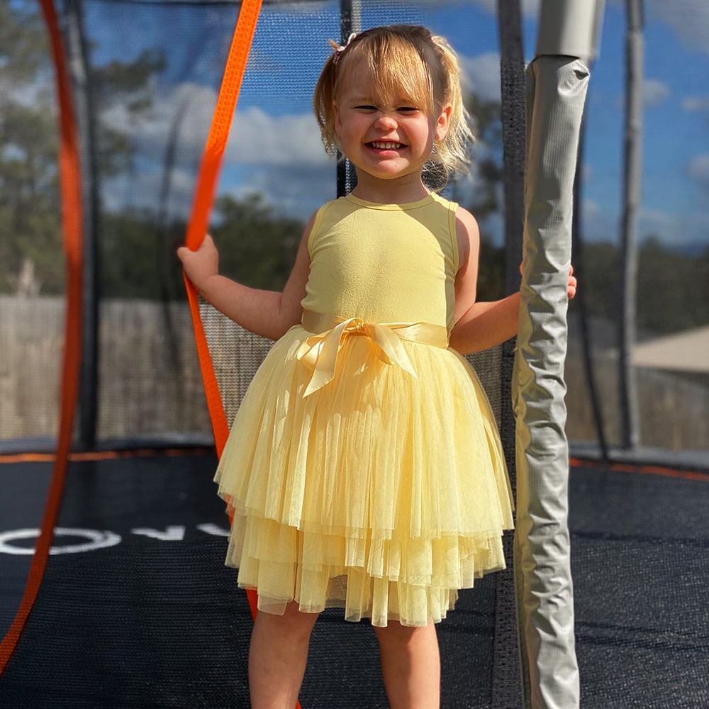 Young girl smiling on trampoline. 