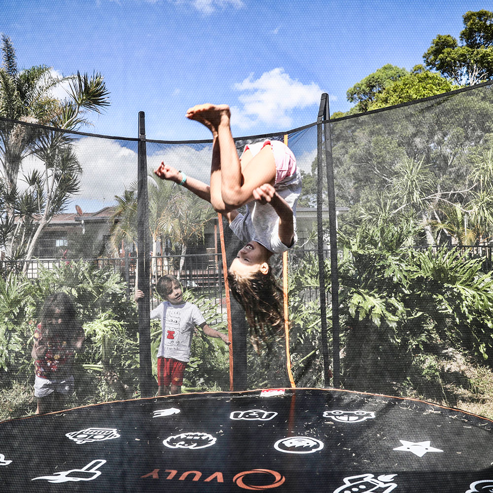 Kids doing back flips on trampolines. 