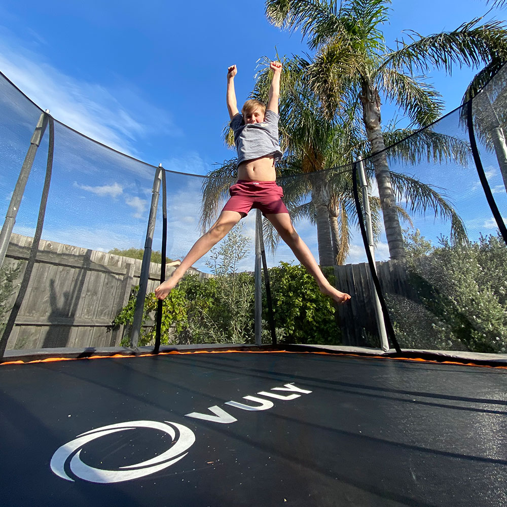 Boy jumping on trampoline.