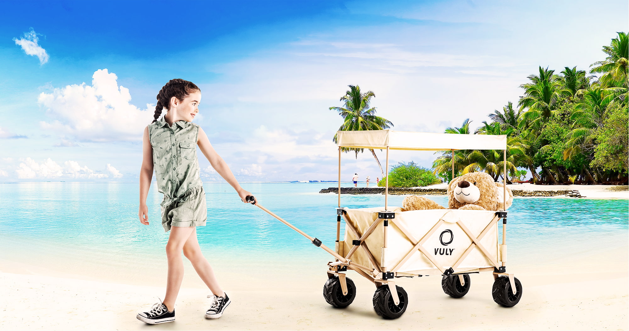 Young girl at the beach towing Rover Beach Edition Wagon Cart carrying teddy bear